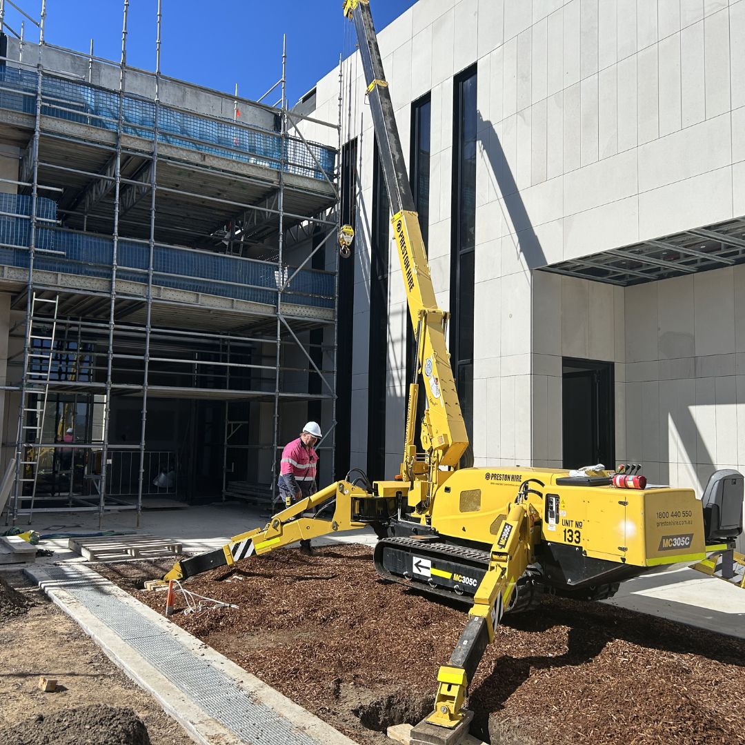 Maeda MC305C mini crane lifting stone façade panels in a tight access embassy project courtyard in ACT with no road closure or outriggers
